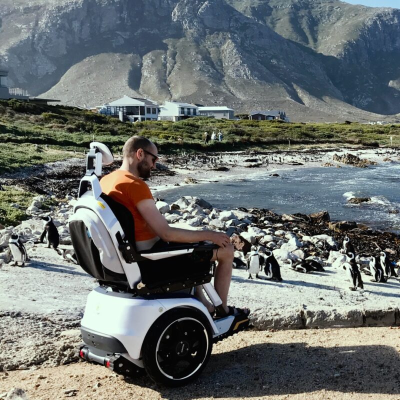 A man in a Scewo BRO electric wheelchair in South Afrika on the beach