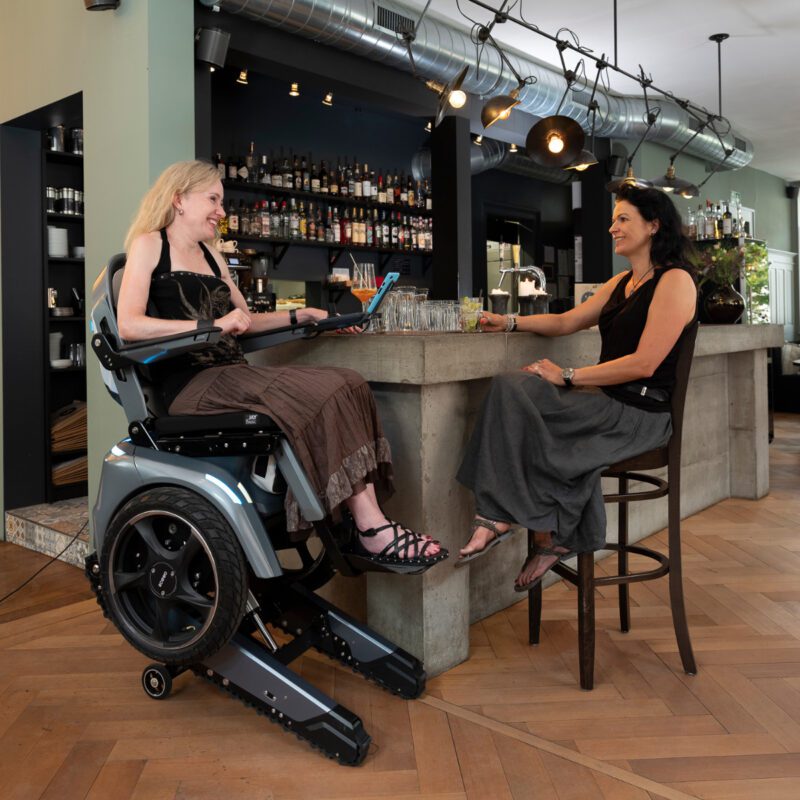 Frau auf Elektrorollstuhl in der Bar
