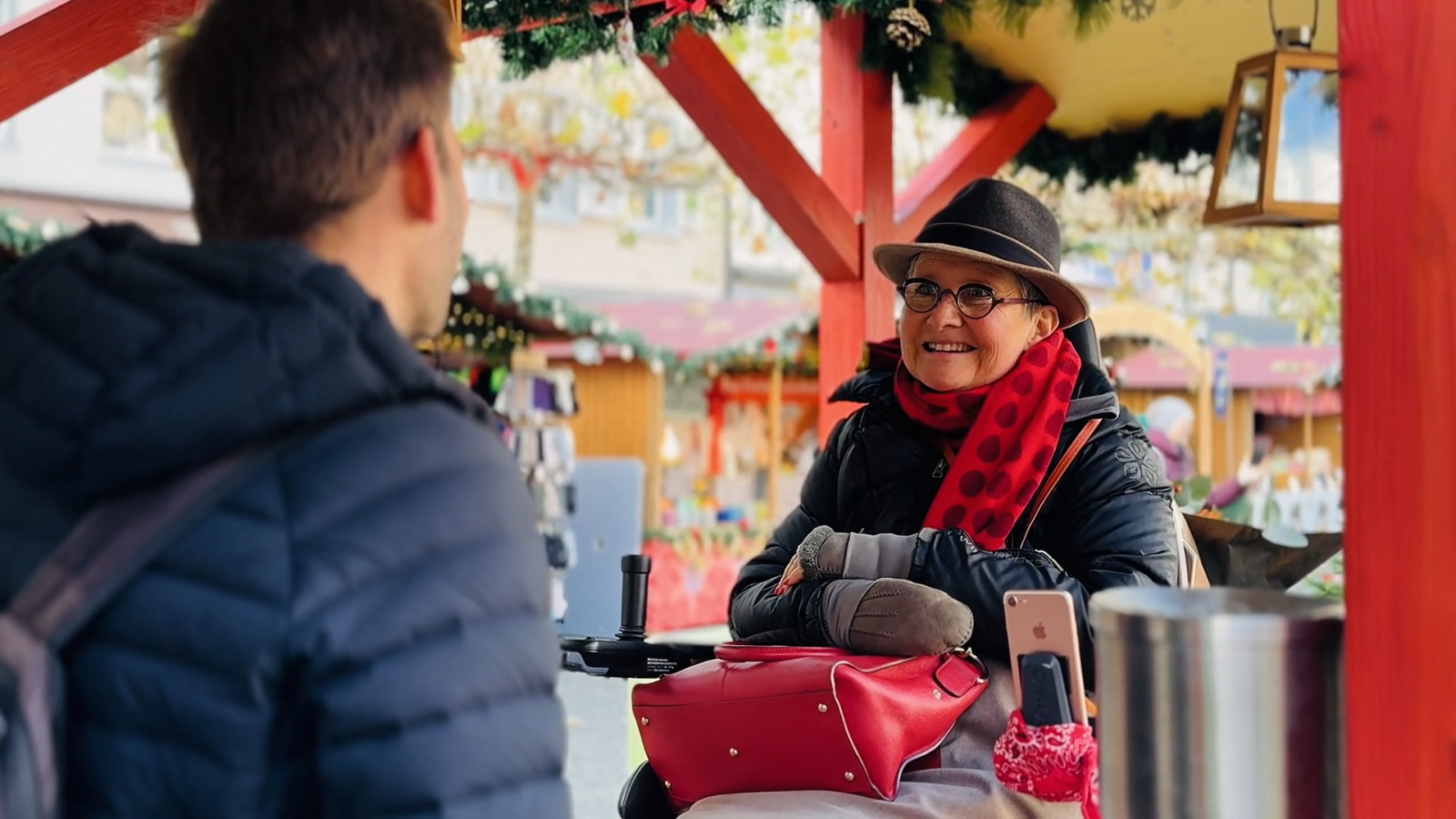 Auf Augenhöhe kommunizieren: Mit dem Sitzlift des Scewo BRO genießt Anne echte Inklusion und Freiheit am Weihnachtsstand.