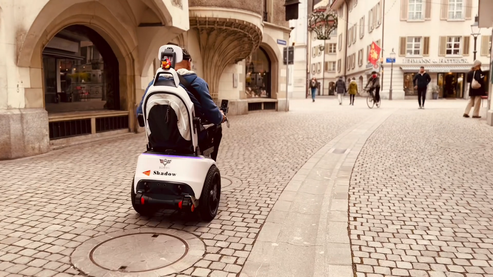Stefan Baumgartner fährt mit seinem Scewo BRO über Kopfsteinpflaster in der Stadt.