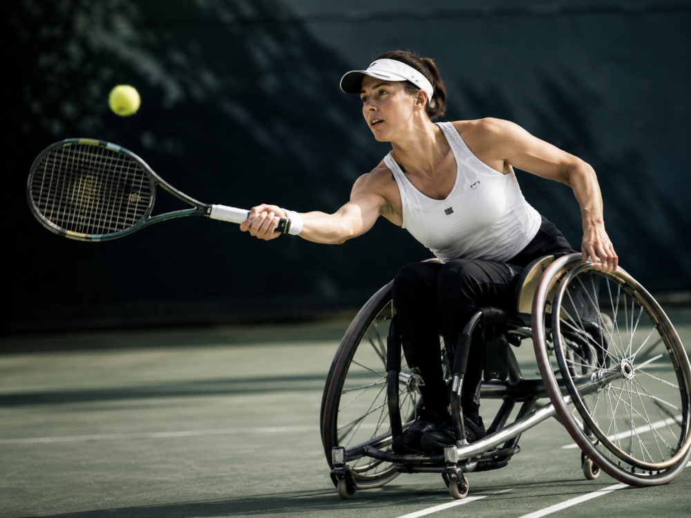 Frau die im Rollstuhl Tennis spielt